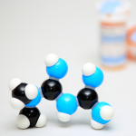 Getty Images. 3D Model of metformin molecular structure with prescription pill bottles.
