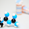 Getty Images. 3D Model of metformin molecular structure with prescription pill bottles.
