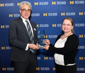 Arthur Lupia, PhD (left), U-M Interim Vice President for Research and Innovation, presents Megan Kellepourey (right) with OVPR Research Administration Staff Safeguard Recognition Award