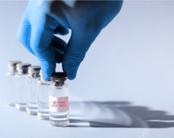 Image of vials being picked up by person with gloved hand