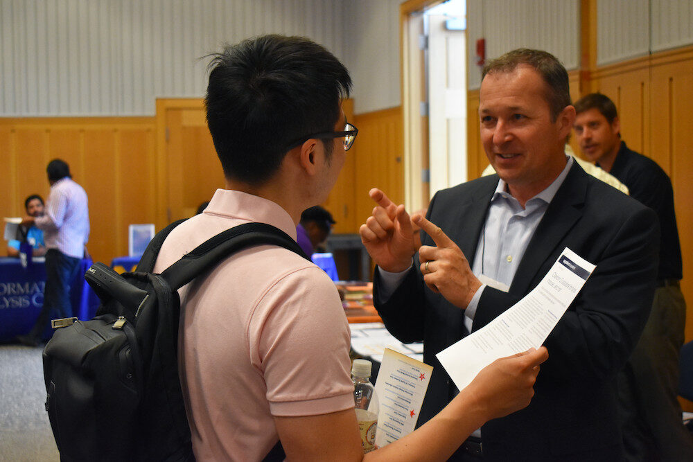Individuals having a conversation at a U-M networking event