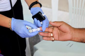 Doctor checking blood sugar level with glucometer